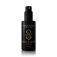 A sleek black bottle of Sagrada BioSkincare’s Copper Vetiver Face Mist – Awaken, Balance, & Renew (100 ml), featuring gold text and a stylized logo, stands out against a white background as a symbol of modern skincare.