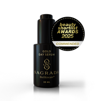 A 30ml bottle of Sagrada BioSkincare Sagrada Day Gold Serum - Radiance Boosting Elixir is displayed next to a gold “beauty shortlist AWARDS 2025 COMMENDED” badge.
