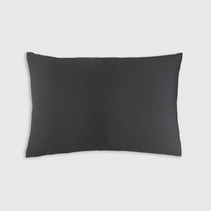 The Sagrada Mulberry Silk Pillowcase by Sagrada BioSkincare, shown in black against a light gray background, highlights its luxurious 22-momme silk texture and thermoregulating benefits for skin and hair while you rest.